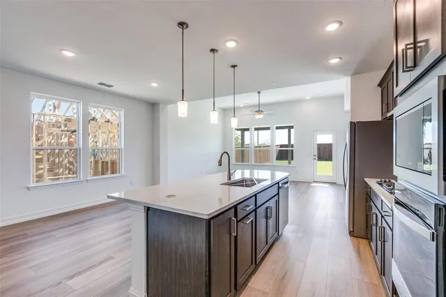 a kitchen with stainless steel appliances granite countertop a kitchen island hardwood floor sink stove and wooden floor