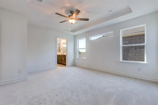 a view of an empty room with chandelier fan and fire place