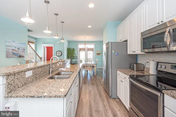 a living room with furniture and a view of kitchen