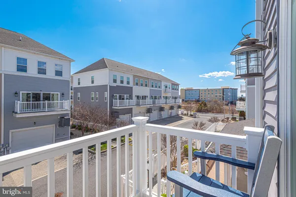 a kitchen with stainless steel appliances kitchen island granite countertop a refrigerator a stove top oven a sink with island and chairs with wooden floor