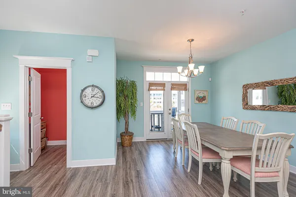 a view of a hallway with wooden floor and a potted plant