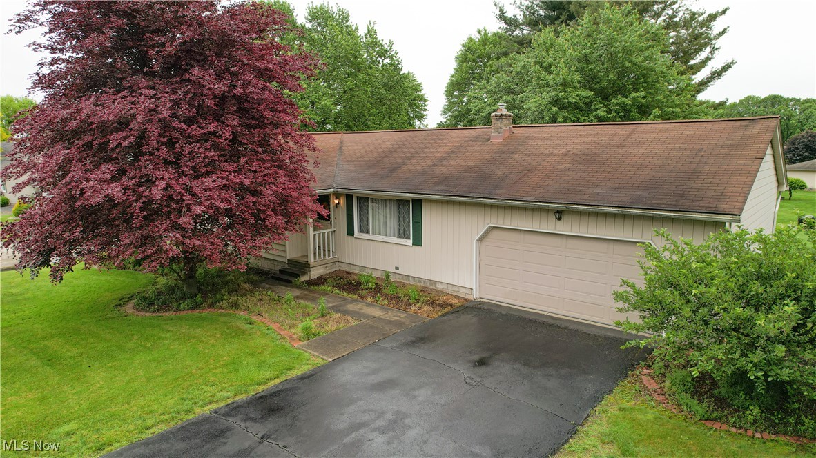 1295 Shields Road Youngstown, OH 44511 - Photo 24 of 27 View of front of house with an attached garage, a shingled roof, a front yard, asphalt driveway, and a chimney