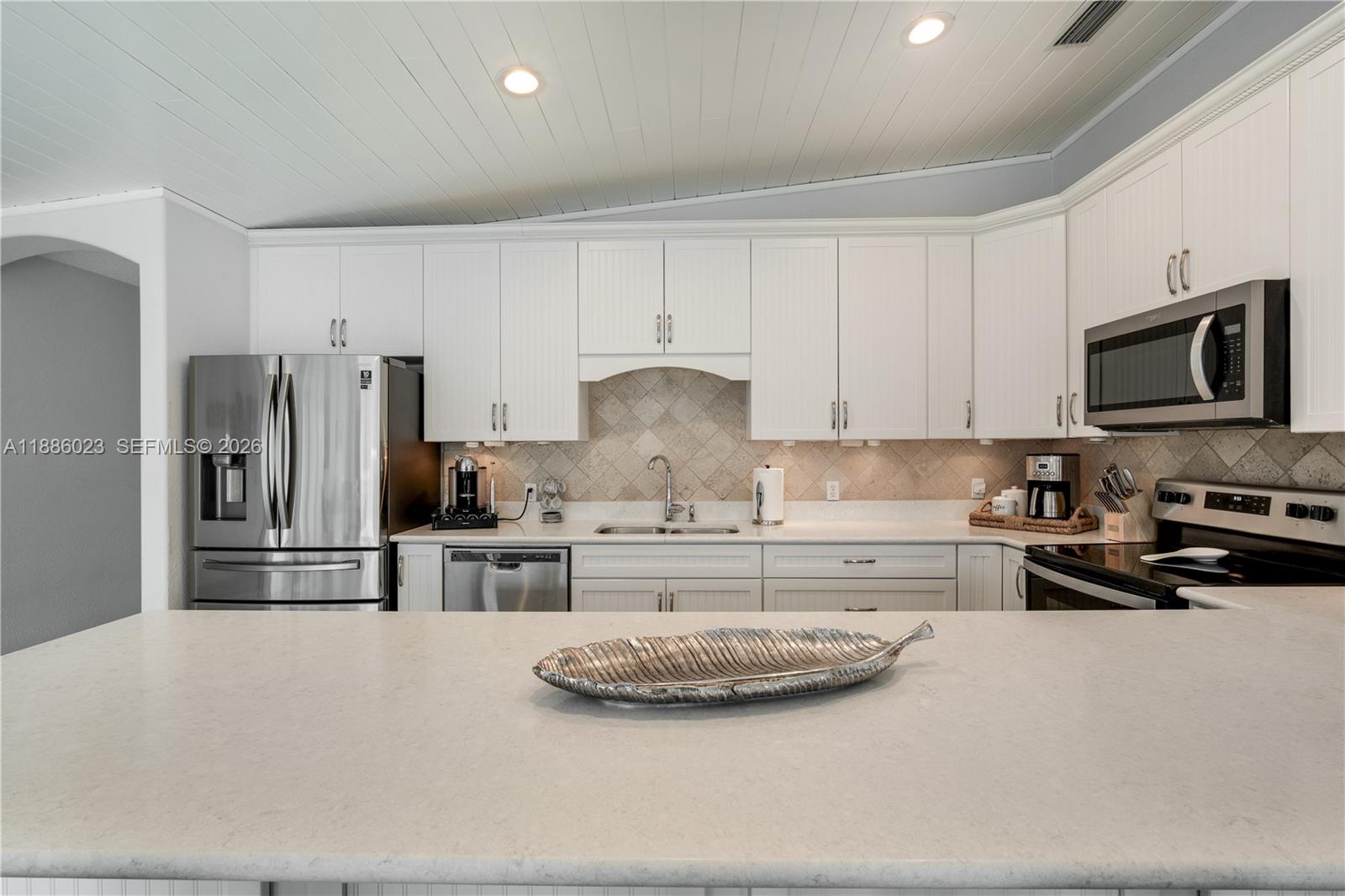 511 4th Street Key Colony Beach, FL 33051 - Photo 16 of 41 a kitchen with stainless steel appliances granite countertop a stove refrigerator and cabinets