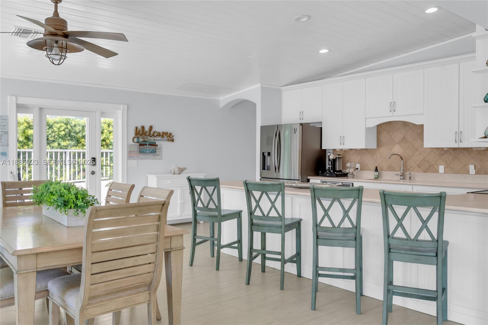 511 4th Street Key Colony Beach, FL 33051 - Photo 17 of 41 a kitchen with stainless steel appliances kitchen island granite countertop a table chairs and a refrigerator