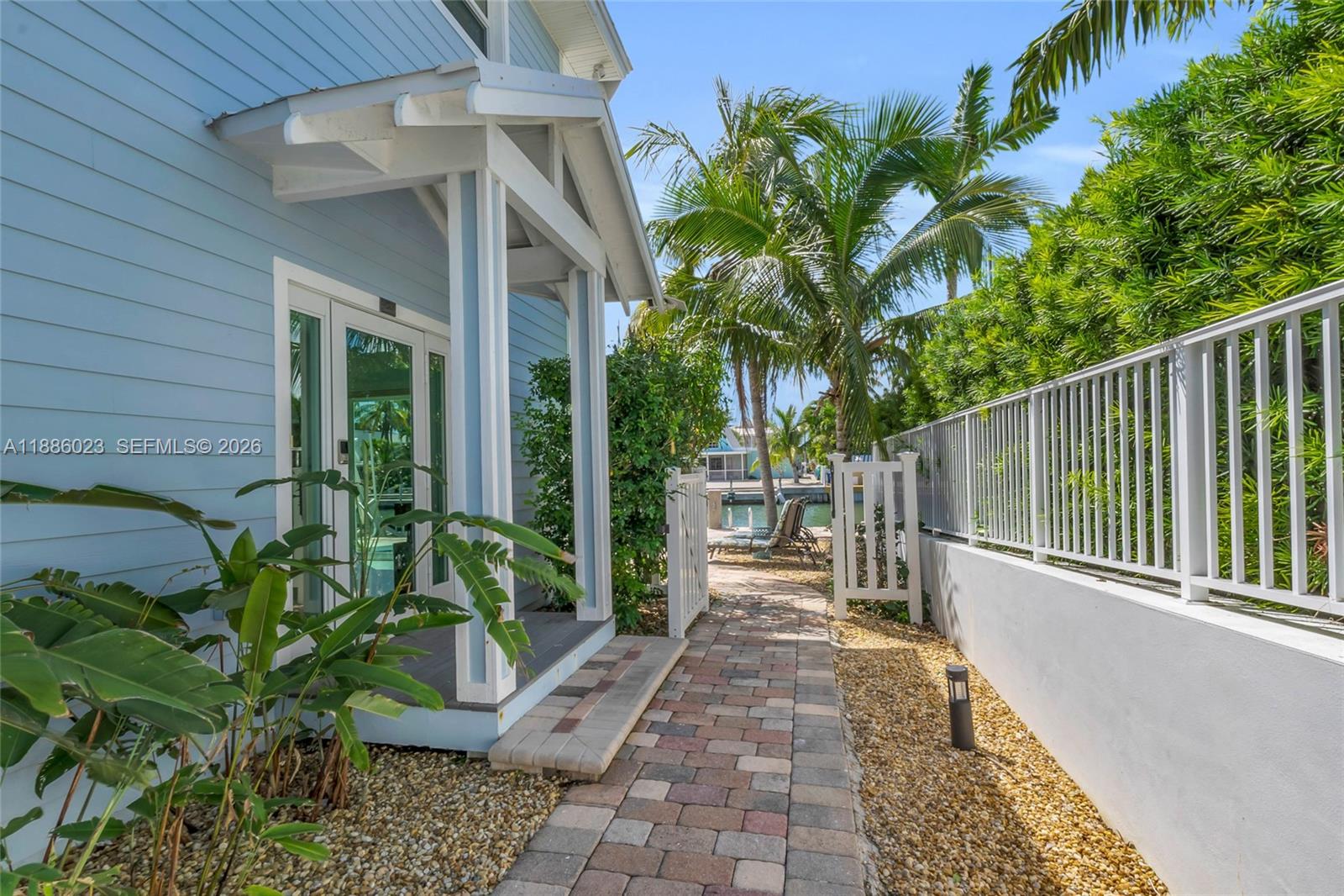 511 4th Street Key Colony Beach, FL 33051 - Photo 38 of 41 a view of a patio with table and chairs potted plants with wooden fence