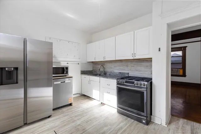 a kitchen with granite countertop a refrigerator stove and oven