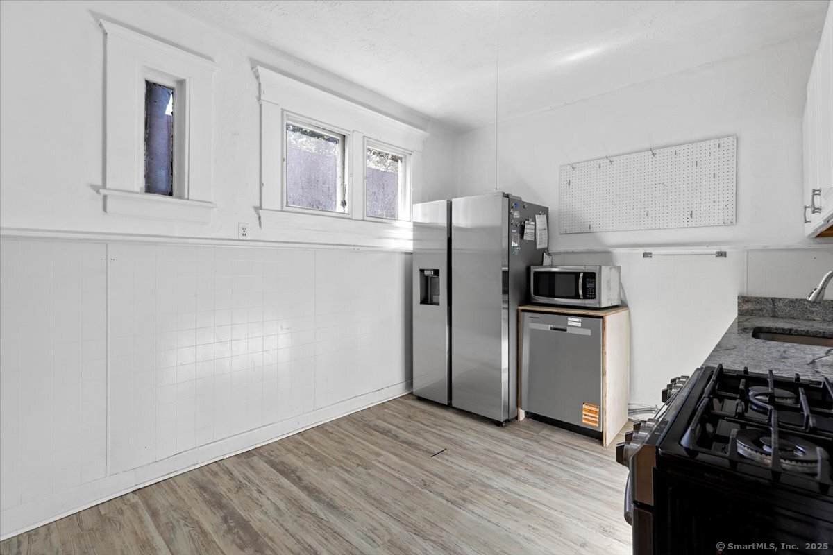 590 Whitney Avenue, Unit 2 New Haven, CT 06511 - Photo 3 of 18 a kitchen with a refrigerator stove and wooden cabinets