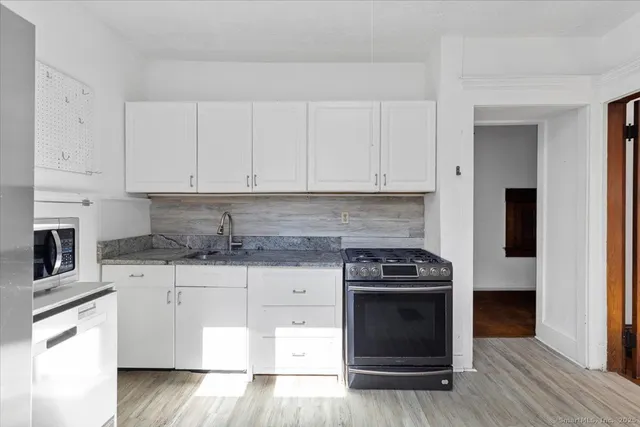 a kitchen with granite countertop a stove and a sink