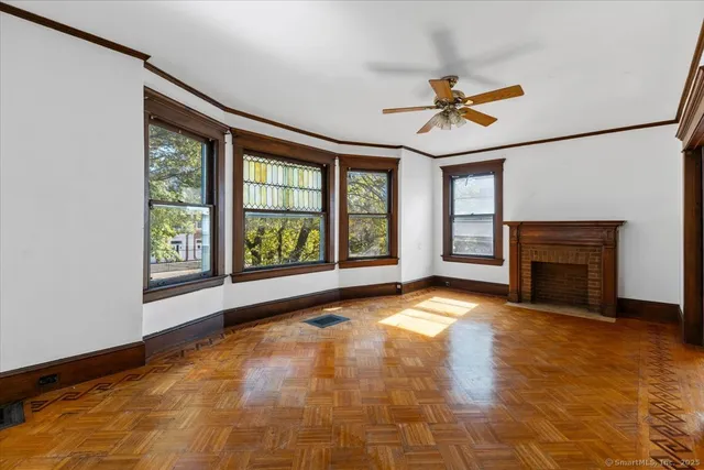 a view of an empty room with a fireplace and a window