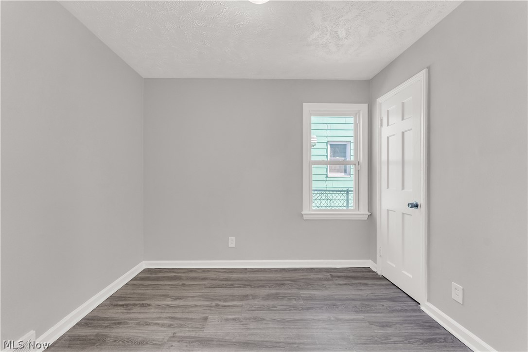 2521 Greenvale Road Cleveland, OH 44121 - Photo 15 of 23 Room with light gray walls, wood-finish flooring, a white trim window, and a white six-panel door
