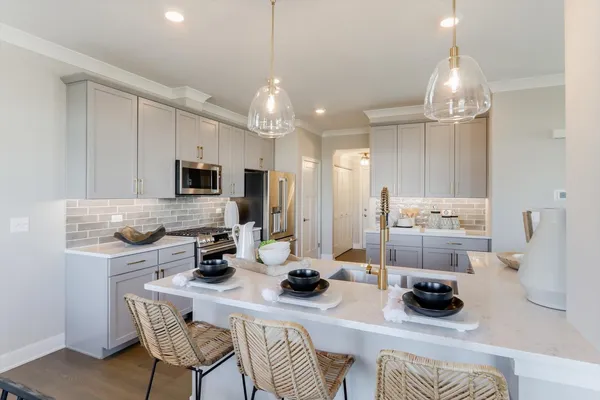 a kitchen with stainless steel appliances kitchen island granite countertop a sink and a refrigerator