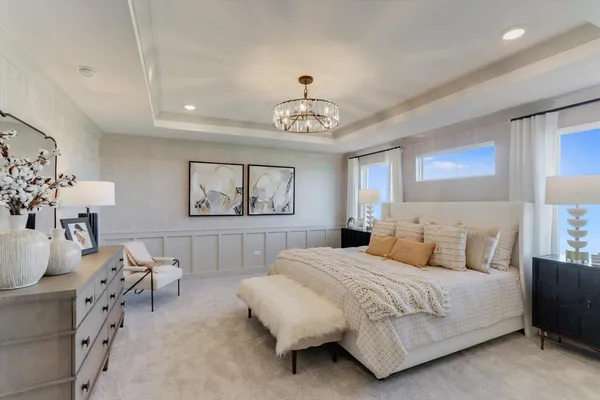 a bedroom with a bed and a chandelier
