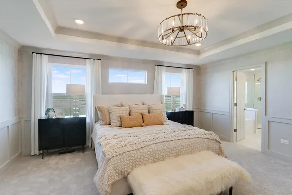 a bedroom with a large bed and a chandelier