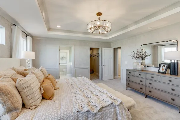 a bedroom with a bed and a chandelier