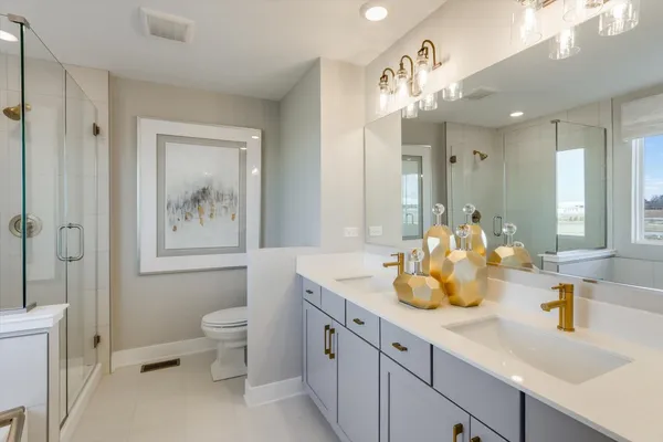 a bathroom with a double vanity sink toilet and shower