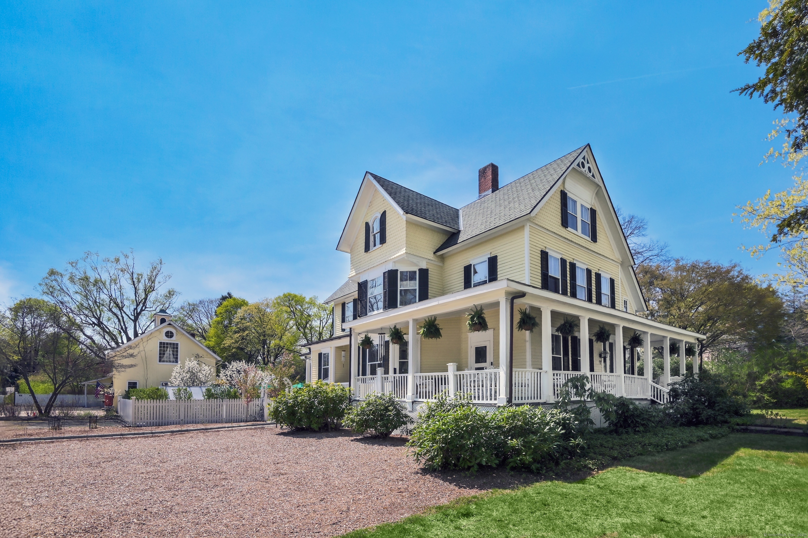 57 Main Street Ridgefield, CT 06877 - Photo 1 of 40 a front view of a house with a garden