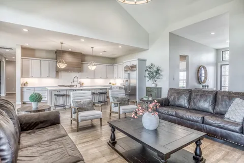 a living room with furniture and a view of kitchen