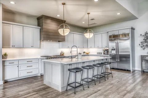 a kitchen with stainless steel appliances granite countertop a sink a stove and a refrigerator