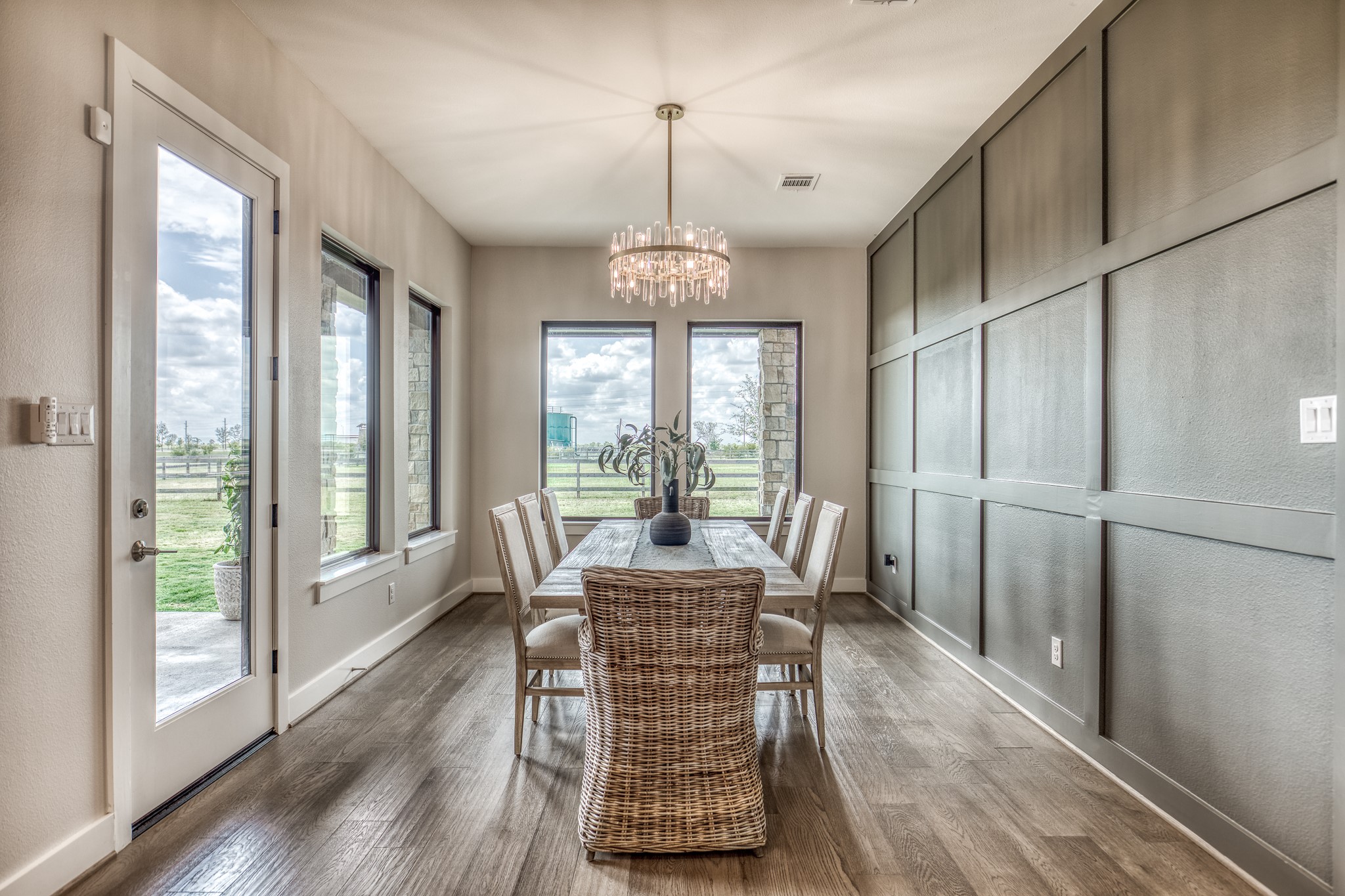 4009 Ranch Home Drive Waller, TX 77484 - Photo 19 of 49 a dining room with furniture large windows a chandelier and wooden floor