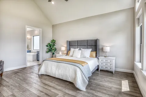 a bedroom with a bed and wooden floor