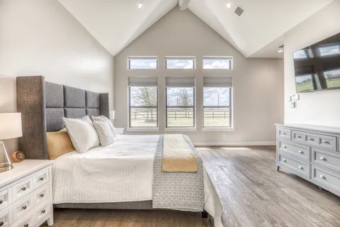 a spacious bedroom with a bed and a dresser
