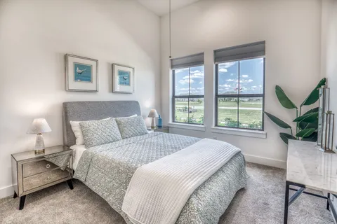 a bedroom with a large bed and a potted plant