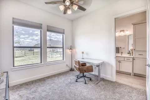 a view of a workspace with furniture and a window