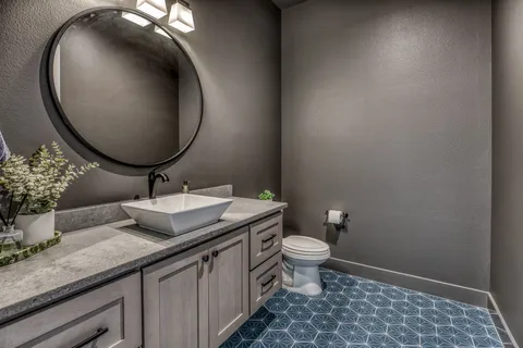 a bathroom with a granite countertop sink and a mirror