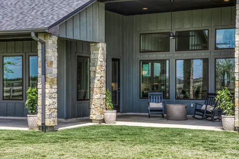 a view of a chair and table in backyard of the house