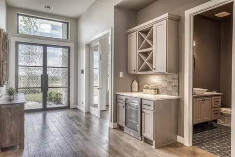 a view of an entryway with wooden floor and cabinets