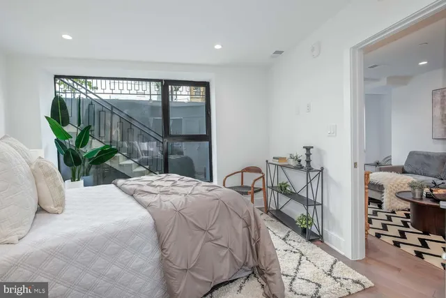 a bedroom with furniture and a large window