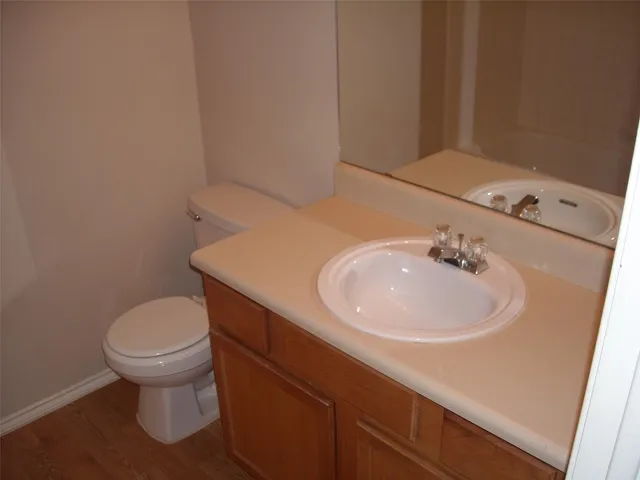 a bathroom with a sink a toilet and a mirror