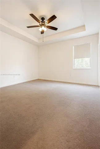 an empty room with a ceiling fan and a window