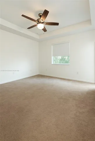 an empty room with a ceiling fan and window