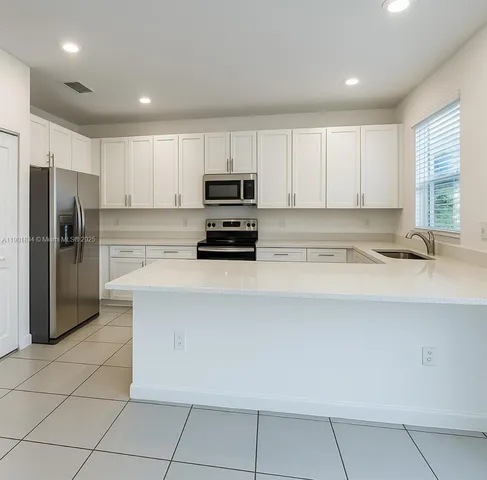 a kitchen with a refrigerator and a stove top oven