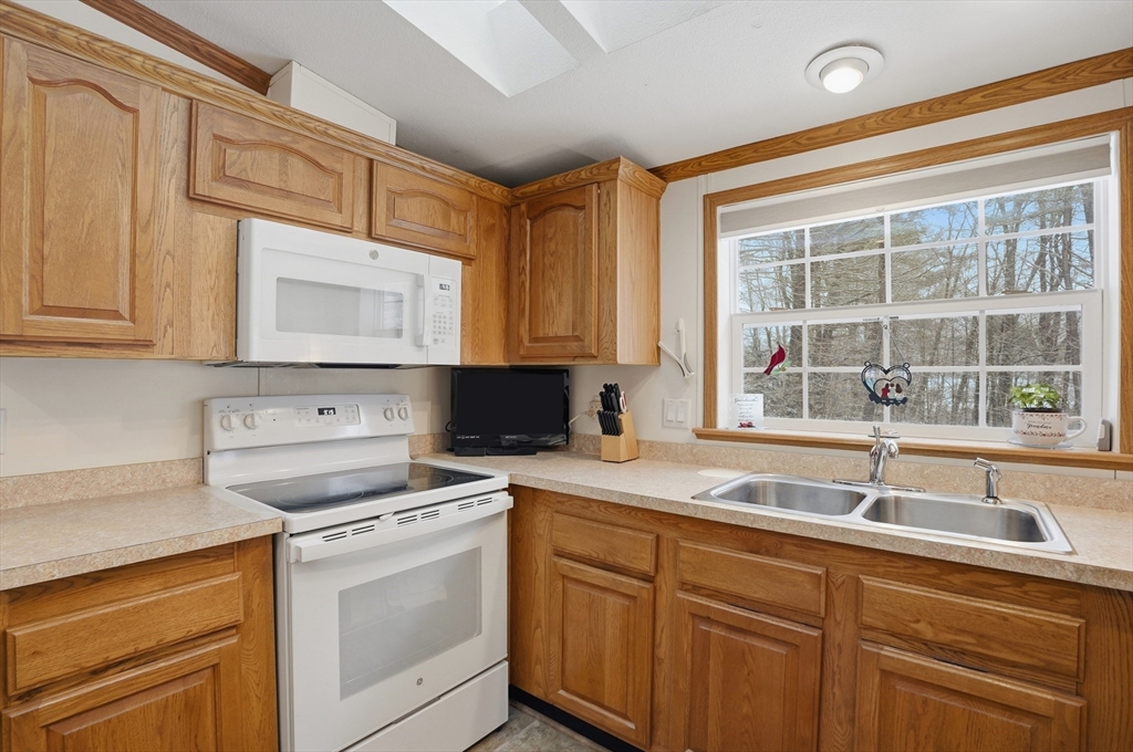 5 Cabot Road Winchendon, MA 01475 - Photo 9 of 31 a kitchen with granite countertop a sink stainless steel appliances white cabinets and a window