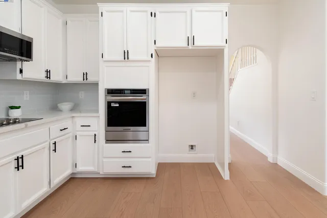 a kitchen with white cabinets and sink