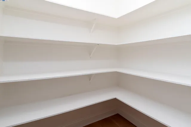 a kitchen with stainless steel appliances kitchen island granite countertop a dining table chairs and a refrigerator