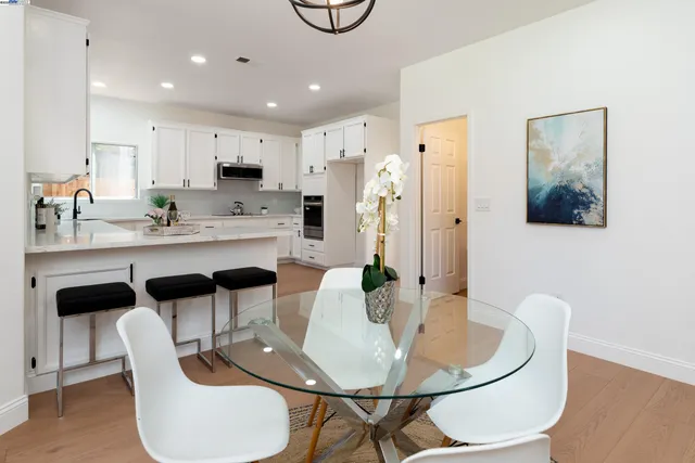 a dining room with furniture a chandelier and wooden floor
