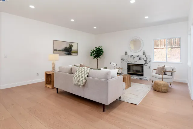a living room with furniture and a view of kitchen