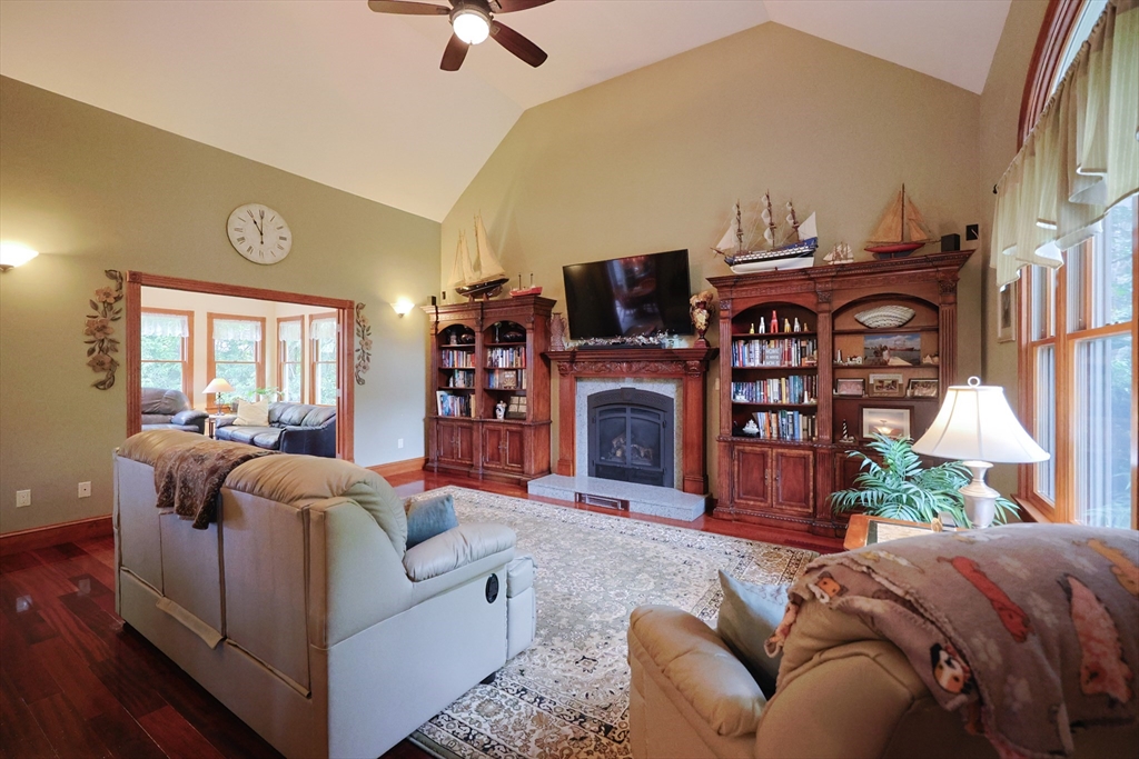 70 Azalea Way Hanson, MA 02341 - Photo 12 of 42 a living room with furniture a fireplace and a flat screen tv
