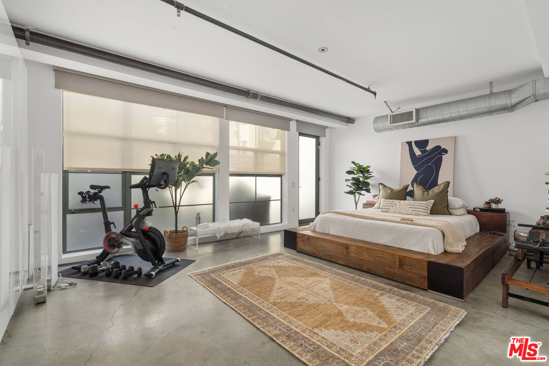 a spacious bedroom with a bed and a large window