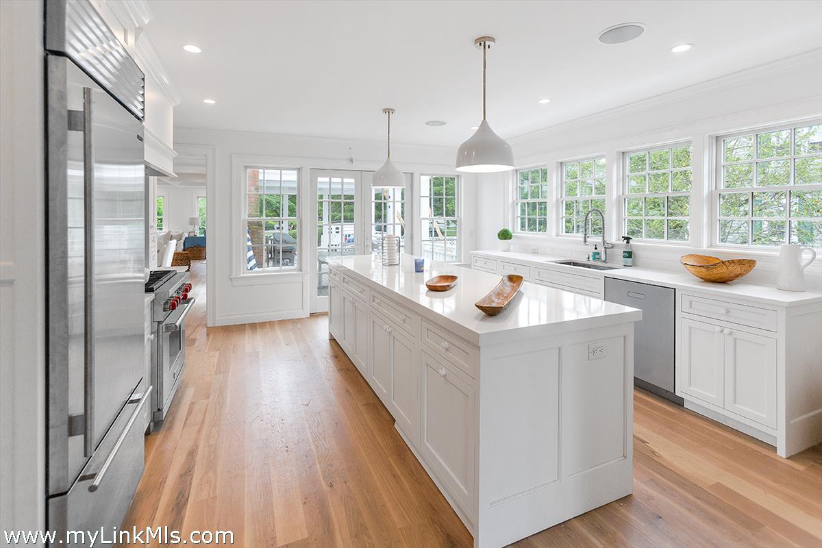 4 Cottle Lane Edgartown, MA 02539 - Photo 14 of 44 a large white kitchen with a large window a sink a counter space and stainless steel appliances