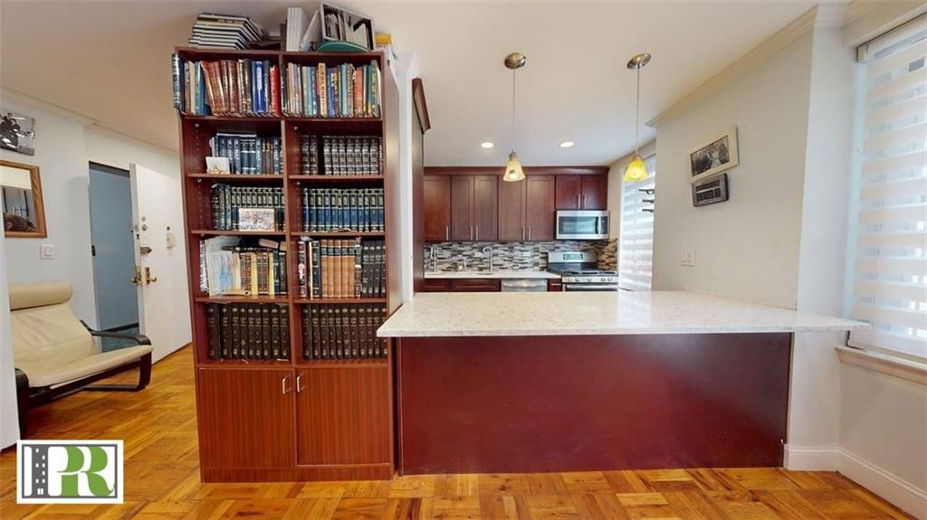 1577 East 17th Street, Unit 2M Brooklyn, NY 11230 - Photo 4 of 10 a kitchen with stainless steel appliances cabinets and a large window