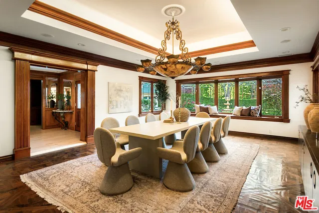 a dining room with wooden floor and a chandelier