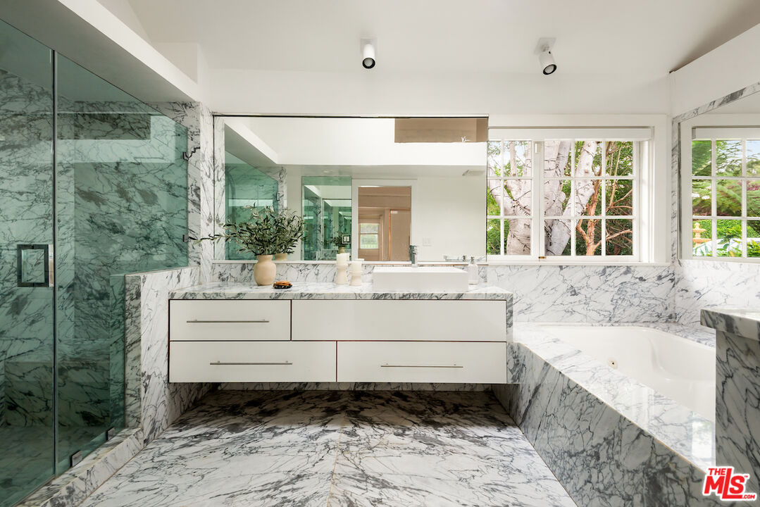 9996 Sunset Boulevard Beverly Hills, CA 90210 - Photo 20 of 35 a bathroom with a bathtub sink and mirror