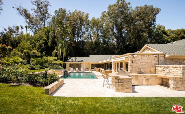 a view of a house with swimming pool and sitting area