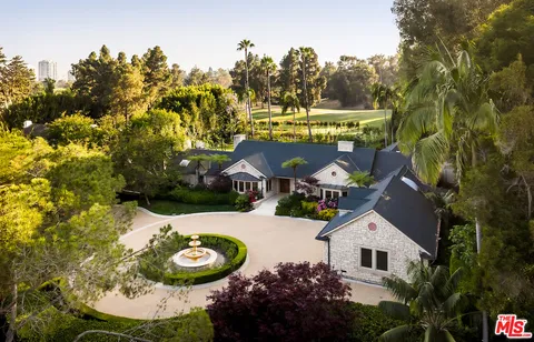 a view of a white house with a yard and garden