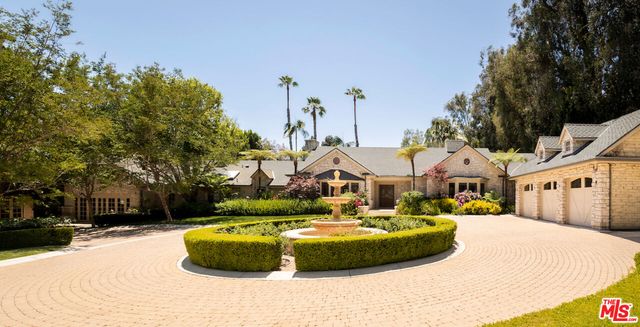 a view of a white house with a swimming pool and sitting area