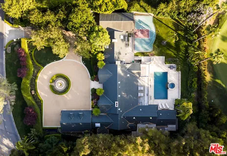 an aerial view of a house with a yard swimming pool and outdoor seating